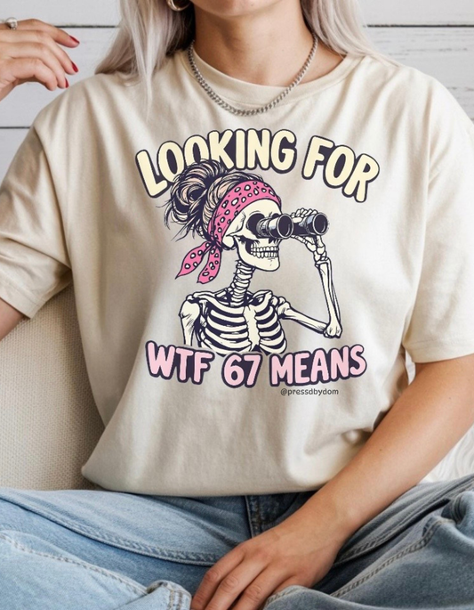 Beige t-shirt with skeleton graphic and text “Looking for WTF 67 Means” – funny sarcastic shirt by Press’d by Dom.